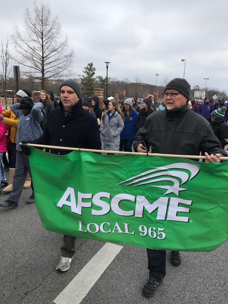 Mike Pierce (left) and Ted Swedenburg represent AFSCME Local 965 at Fayetteville's Martin Luther King Jr. march Jan. 15, 2018.