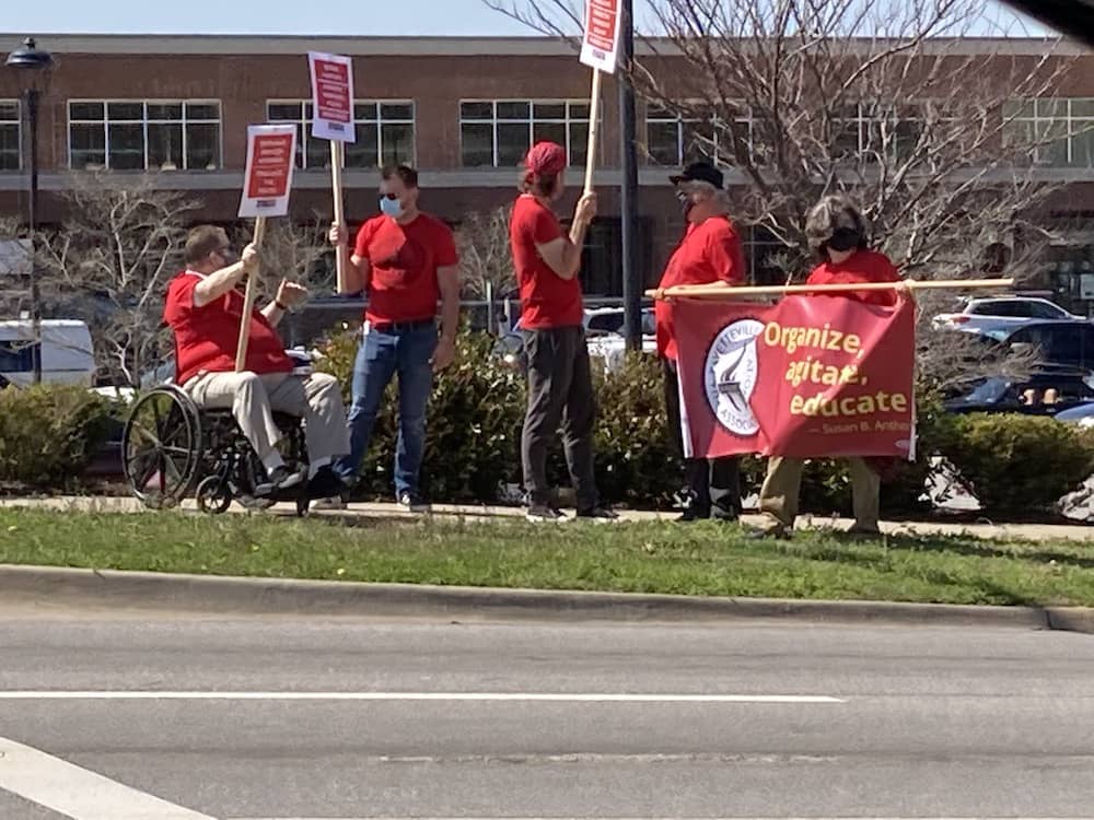 Hershel Hartford, Bret Schulte, Geoff Brock, Ted Swedenburg and Ben Pollock discuss Local 965 business at the Solidarity with Amazon Workers rally March 20, 2021, outside the Fayetteville Whole Foods Market.