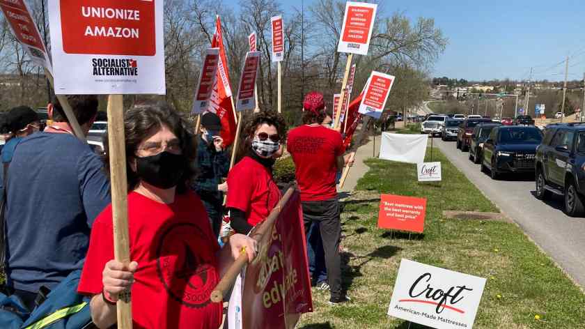 Red-shirted 965 members Ben Pollock, Tricia Starks and Geoff Brock join the Solidarity with Amazon Workers rally March 20, 2021, outside the Fayetteville Whole Foods Market.