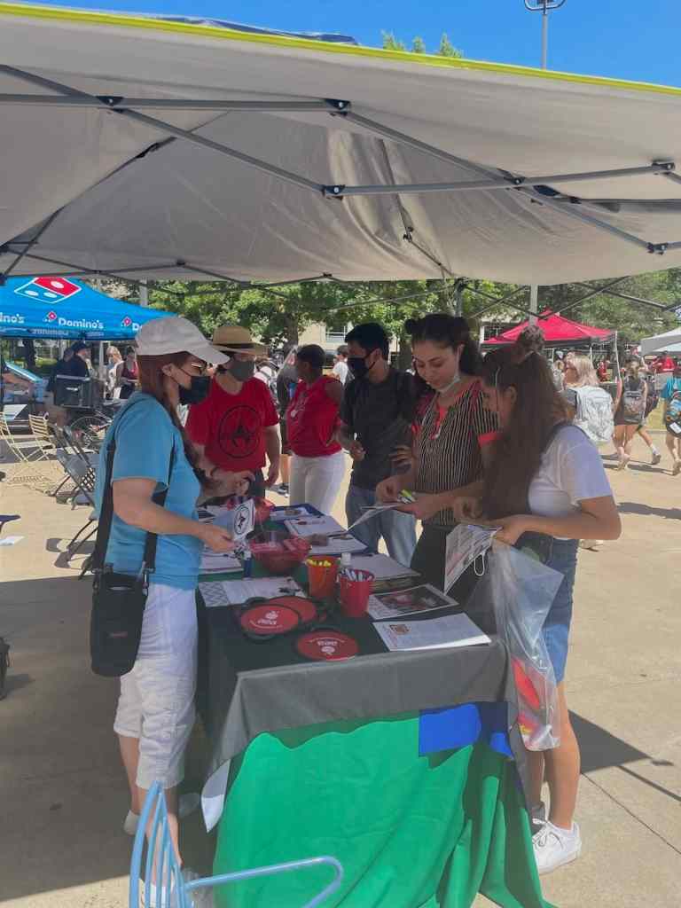 AEA UniServ Director Renee Johnson, Local 965 Secretary Ben Pollock and AEA Organizing and Field Services Manager Karla Carpenter answer questions of three students at UA's Razorbash fair Aug. 26, 2021.