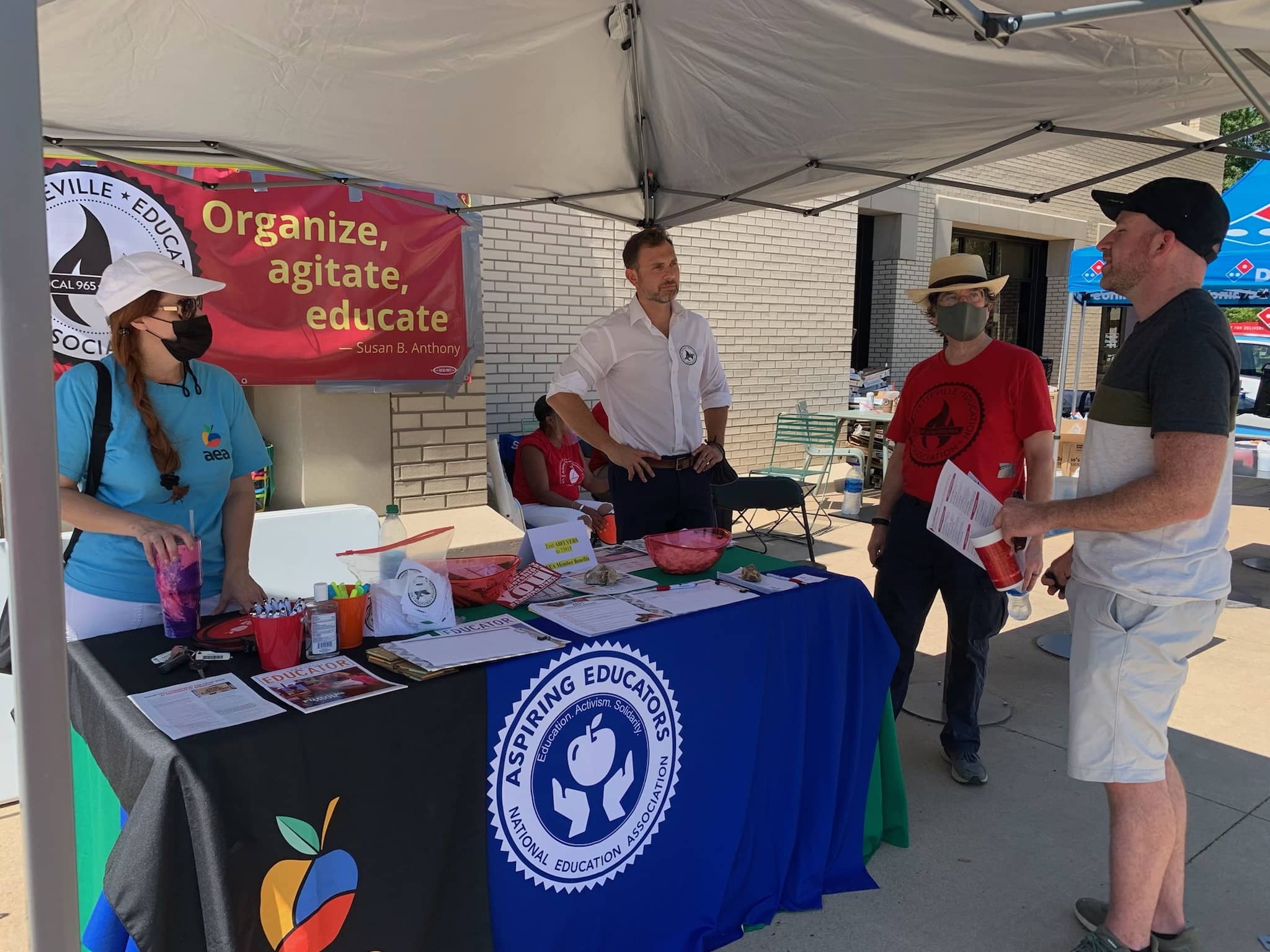 A student asks questions of AEA UniServ Director Renee Johnson and Local 965 President Bret Schulte and Secretary Ben Pollock at the Aug. 25, 2021, Razorbash community fair on UA's Fayetteville flagship campus.