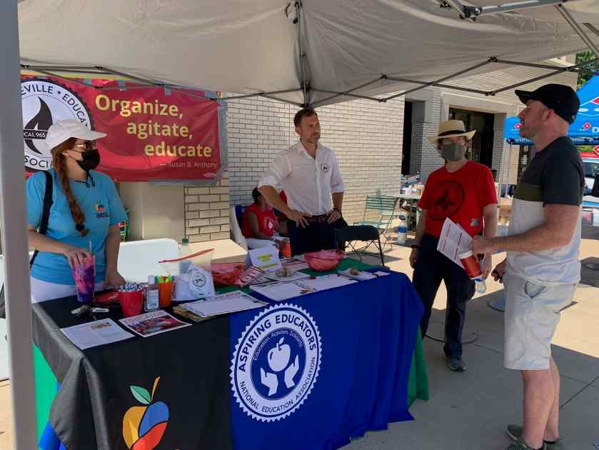 A student asks questions of AEA UniServ Director Renee Johnson and Local 965 President Bret Schulte and Secretary Ben Pollock at the Aug. 25, 2021, Razorbash community fair on UA's Fayetteville flagship campus.