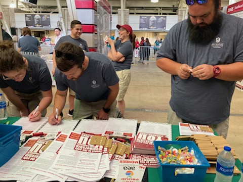 Several U of A staff members examine the brochures or sign up for the Local 965 mailing list May 19 at the 2022 Staff Appreciation Picnic at Reynolds Razorback Stadium.
