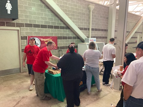 965 At-Large Board Member Chad Kieffer answers questions of a U of A staff member as others stand by May 19 at the 2022 Staff Appreciation Picnic at Reynolds Razorback Stadium.