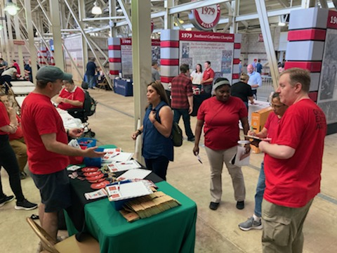 Local 965 Vice President Mike Pierce talks across the table with a U of A staff member May 19 at the 2022 Staff Appreciation Picnic at Reynolds Razorback Stadium. At-large Board Member Chad Kieffer answers questions of two other staff employees.