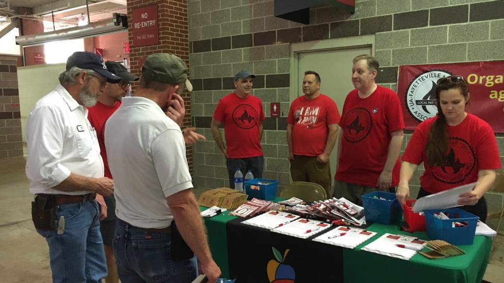 965 President Bret Schulte talks with two U of A staff members May 19 at the 2022 Staff Appreciation Picnic at Reynolds Razorback Stadium.