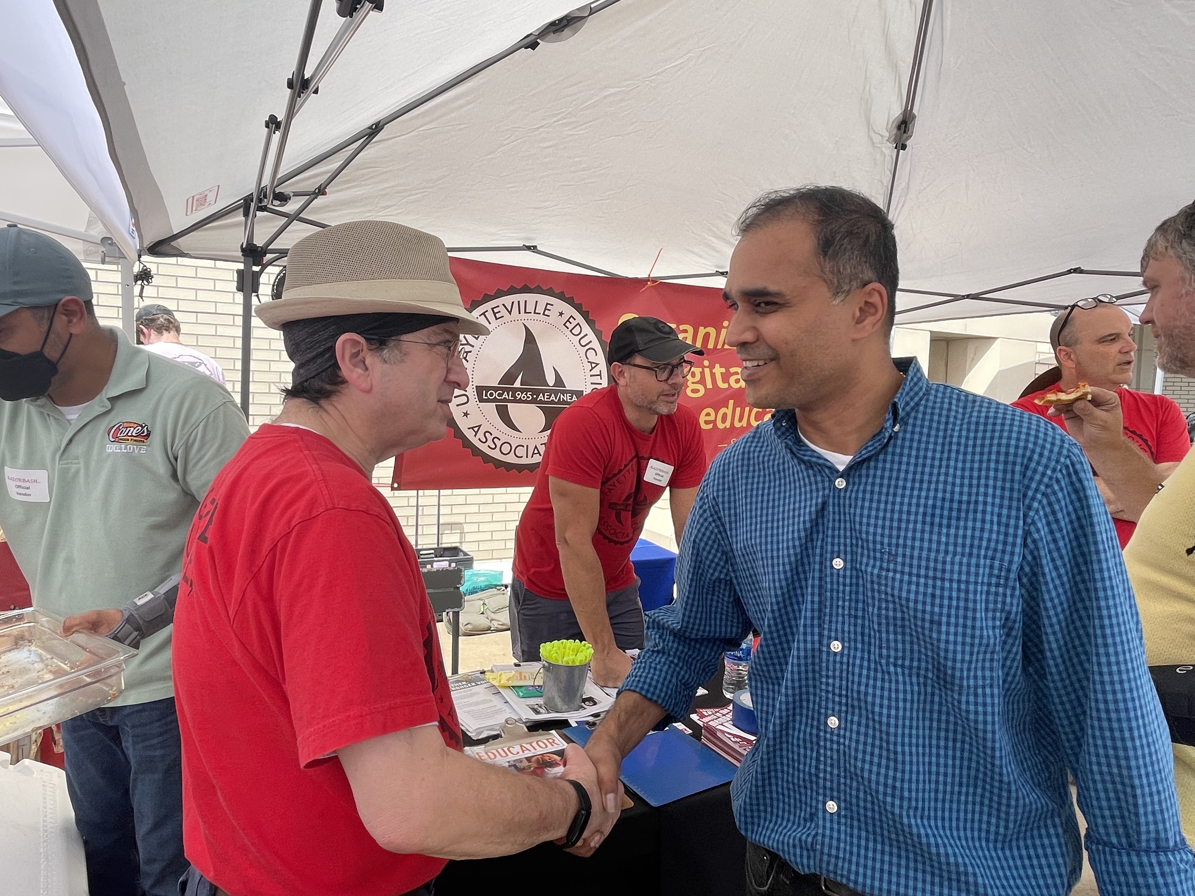 Local 965 Secretary Ben Pollock makes personal contact as President Bret Schulte and Vice President Mike Pierce talk with other University of Arkansas employees and graduate students Aug. 24 at the 2022 Razorbash community fair on the Fayetteville campus.