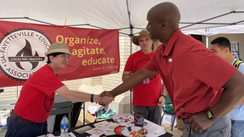 Local 965 Secretary Ben Pollock greets interim University of Arkansas Chancellor Charles F. Robinson Aug. 24 at the 2022 Razorbash on the Fayetteville campus as 965 Vice President Mike Pierce listens.