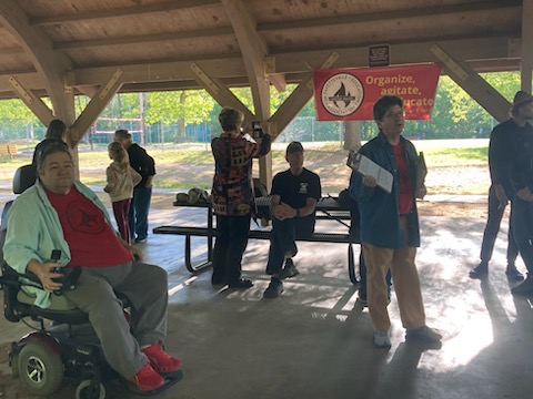 Local 965 President Hershel Hartford (from left) listens as state Rep Denise Garner snaps a photo and her husband, Dr. Hershey Garner looks on as Vice President Ben Pollock hawks memberships at the Local 965 Workers Day 2023 picnic May 1.