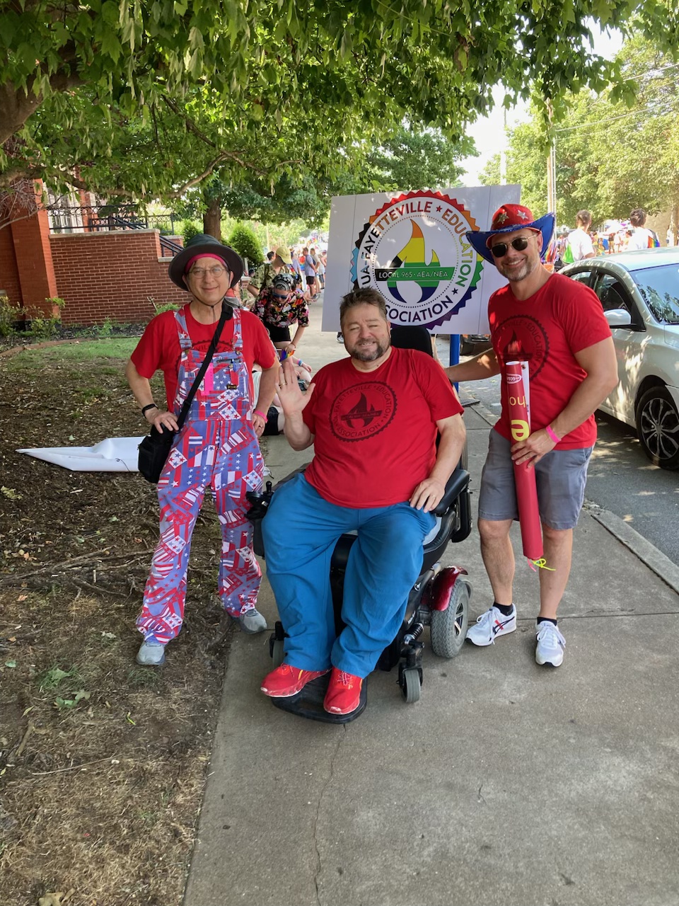 Local 965 Vice President Ben Pollock, President Hershel Hartford and Past President Bret Schulte enjoy the shade as paraders line up June 24, 2023, for the 19th annual NWA Pride Parade.