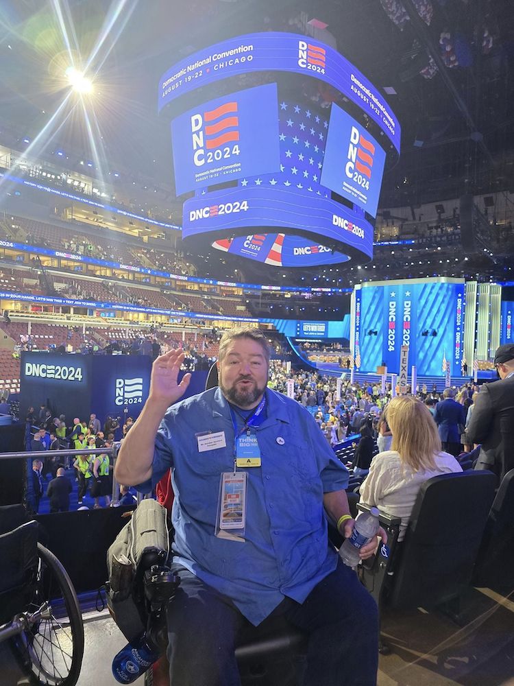 Local 965 President Hershel Hartford awaits the first night of speeches at the 2024 Democratic National Convention in Chicago, sitting with the Democratic Party of Arkansas delegation.