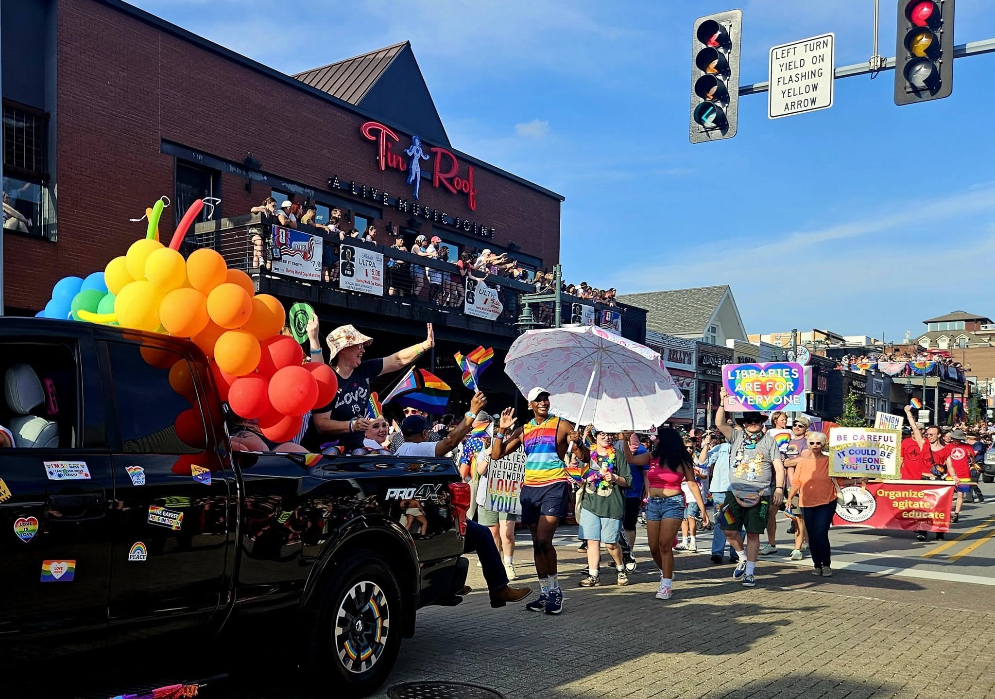 The Local 965 approaches behind its red banner, as part of the 2026 Northwest Arkansas Pride Parade on June 27.