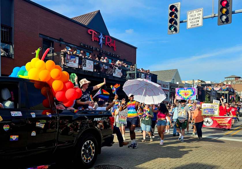 The Local 965 approaches behind its red banner, as part of the 2026 Northwest Arkansas Pride Parade on June 27.